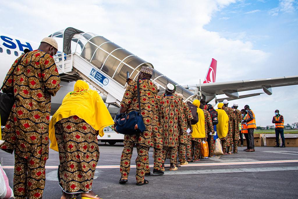 Image de Société. Ce dimanche 11 juin 2023, à 13h07, le premier convoi des pèlerins béninois pour le Hadj 2023 a quitté l'Aéroport de Cotonou. À bord de l'avion se trouvaient 306 pèlerins, y compris un bébé. Avant leur départ, le Ministre des Affaires étrangères et Président du Comité d'Orientation et de Supervision du Hadj, M. Olushegun BAKARI, accompagné de la DG AGLO, Mme Ghislaine MENSAH, a rassuré les pèlerins quant aux mesures prises par le gouvernement pour garantir un déroulement optimal du pèlerinage. Le Ministre a également appelé les pèlerins à prier pour le Bénin, le Chef de l'État Patrice Talon, et à respecter les directives des autorités saoudiennes lors de leur séjour à La Mecque. Cette édition du Hadj 2023 est-elle prête à offrir une expérience spirituelle mémorable aux pèlerins béninois ?